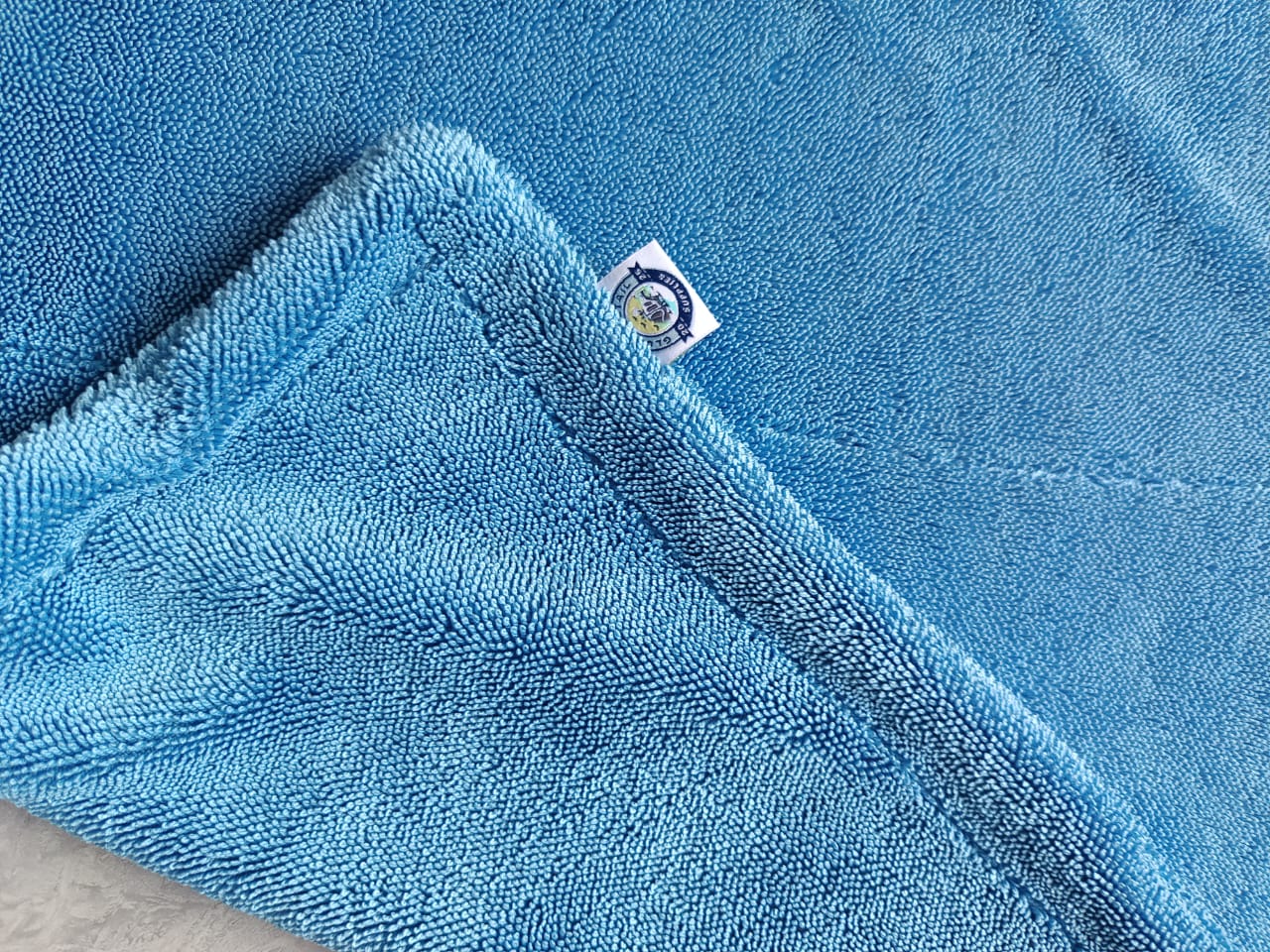 Close-up of blue AeroWipe Max microfiber drying towel showing soft texture and stitched edges for detailing use
