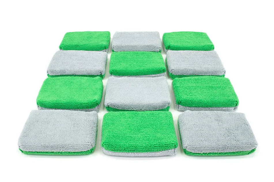 Twelve thin microfiber coating applicator sponges in green and gray colors arranged on white background