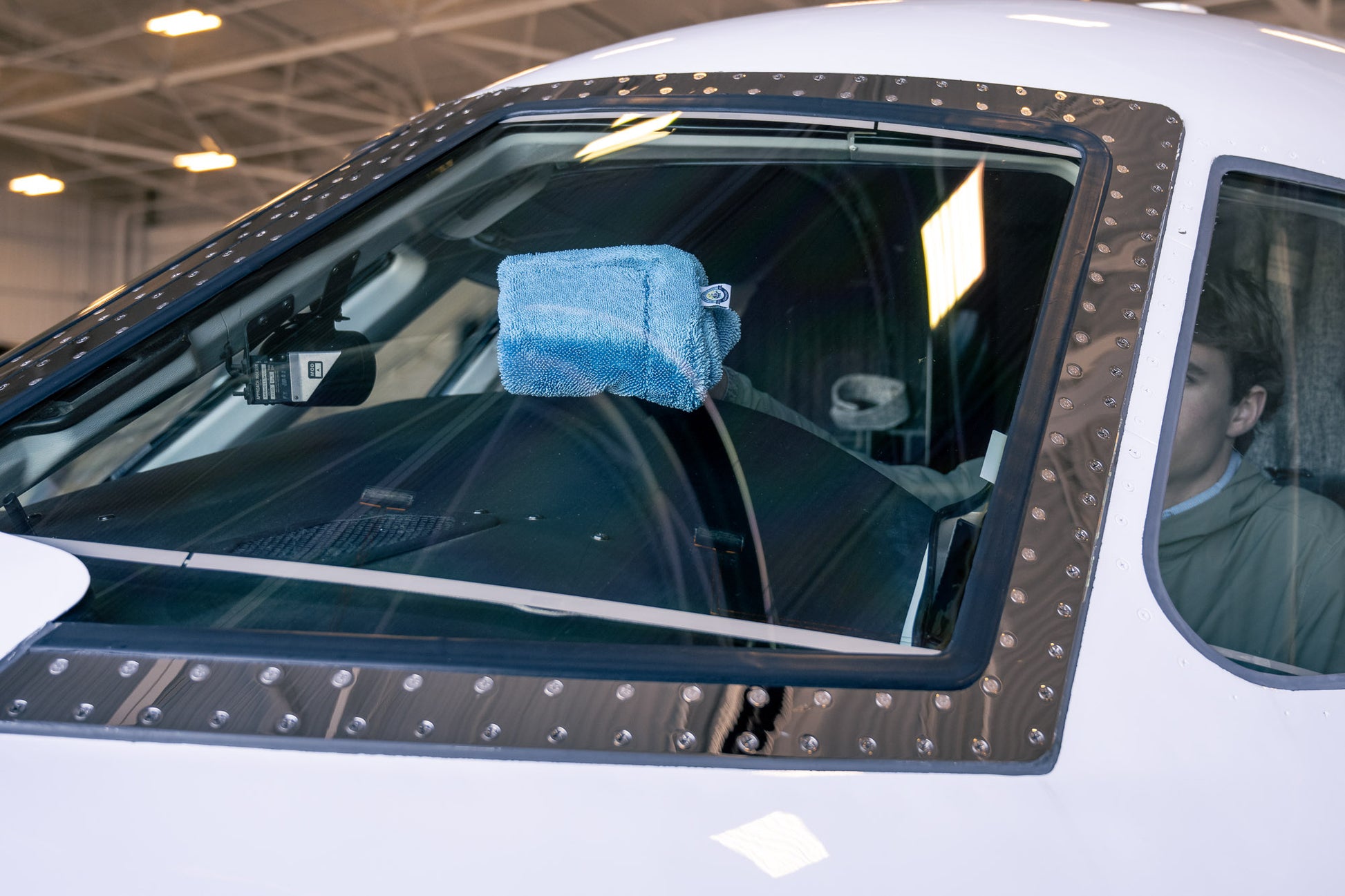 Blue AeroWipe Mini small microfiber drying towel resting on the cockpit windshield of a small aircraft