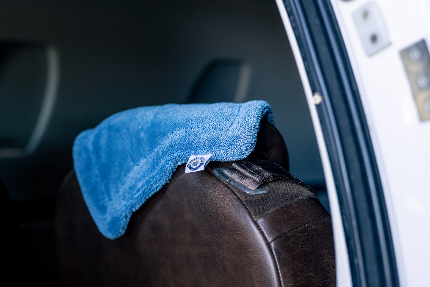 Blue AeroWipe Mini microfiber drying towel folded and draped over aircraft seat for precision drying and detailing